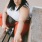 lifestyle image of a woman sitting on a bench in workout clothes